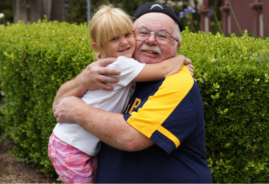 Neta abraçando avô. Imagem ilustrativa texto Dia dos Avós.