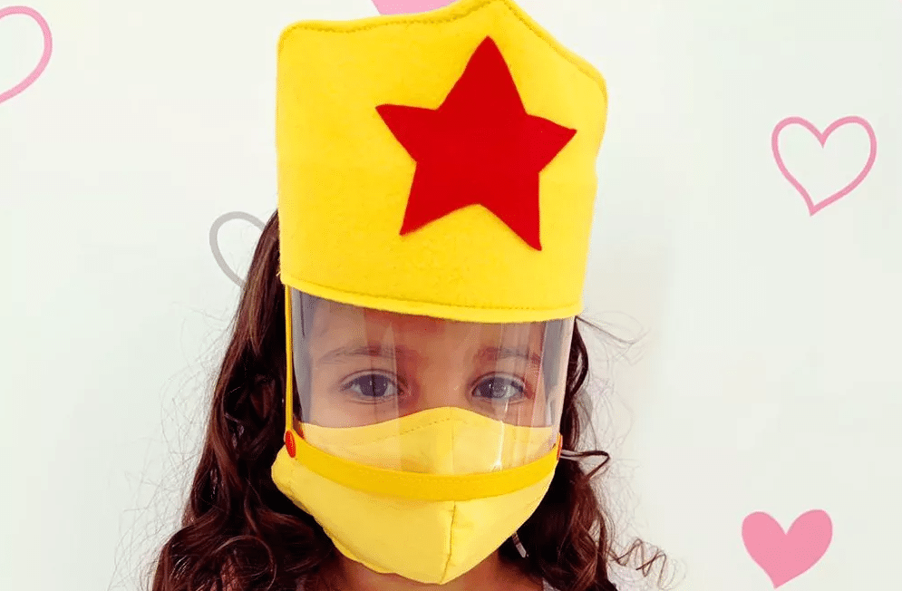 Menina usando máscara de proteção infantil customizada. Imagem ilustrativa texto customizar máscara infantil.​
