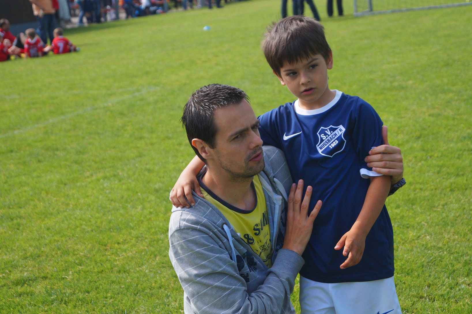 Pai com menino no campo de futebol. Imagem ilustrativa texto iniciar as crianças nos esportes.