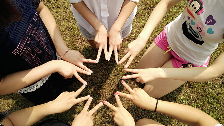 Meninas ao ar livre, visão por cima formando uma estrela com os dedos. Imagem ilustrativa texto importância da brincadeira.