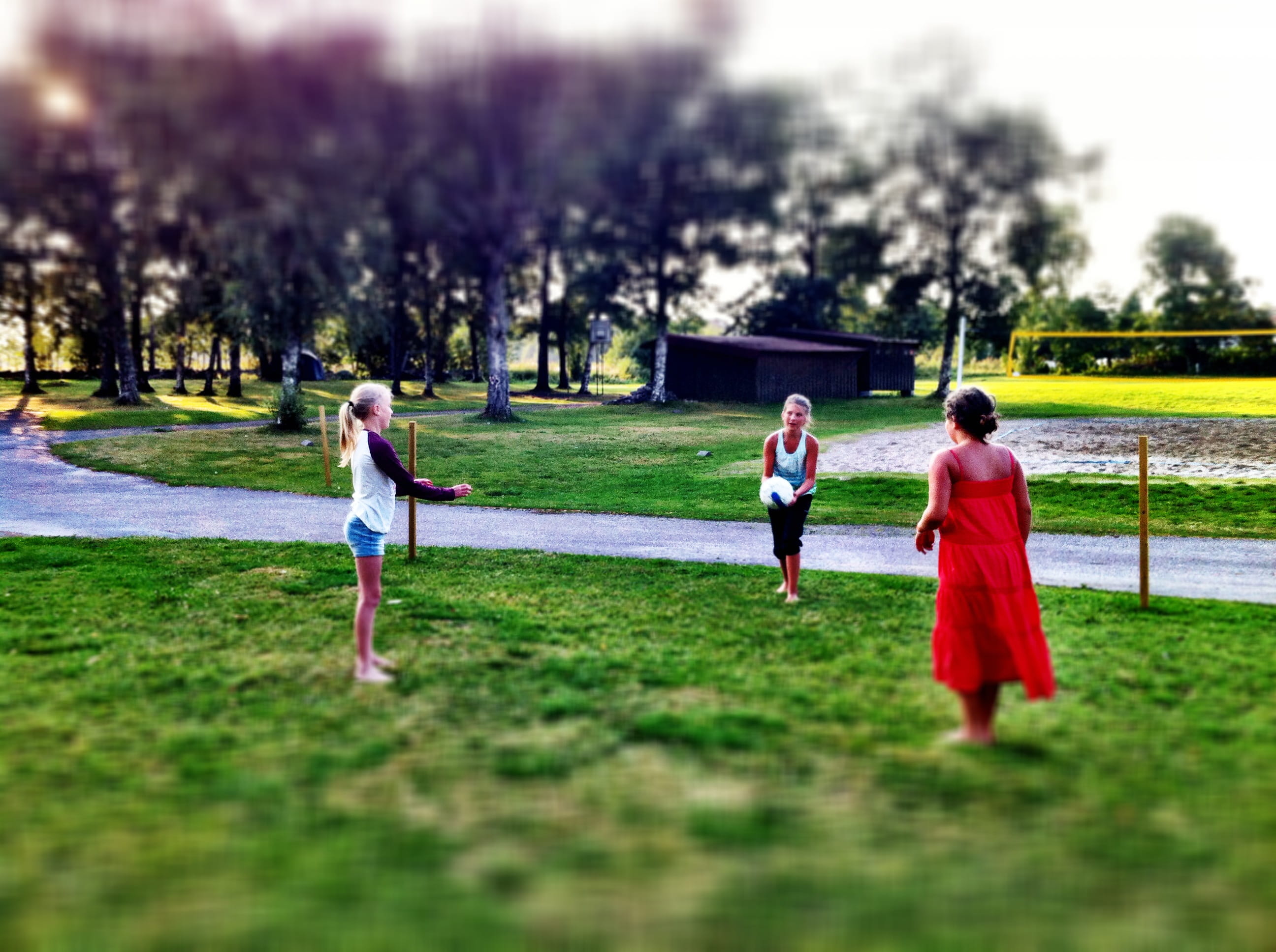 Três meninas jogando bola ao ar livre. Imagem ilustrativa texto importância da brincadeira.