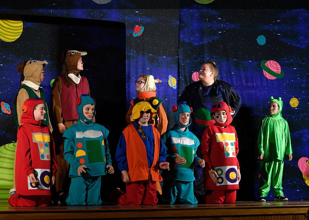 Teatro infantil, com crianças vestindo como personagens. Imagem ilustrativa texto campo artístico-literário.